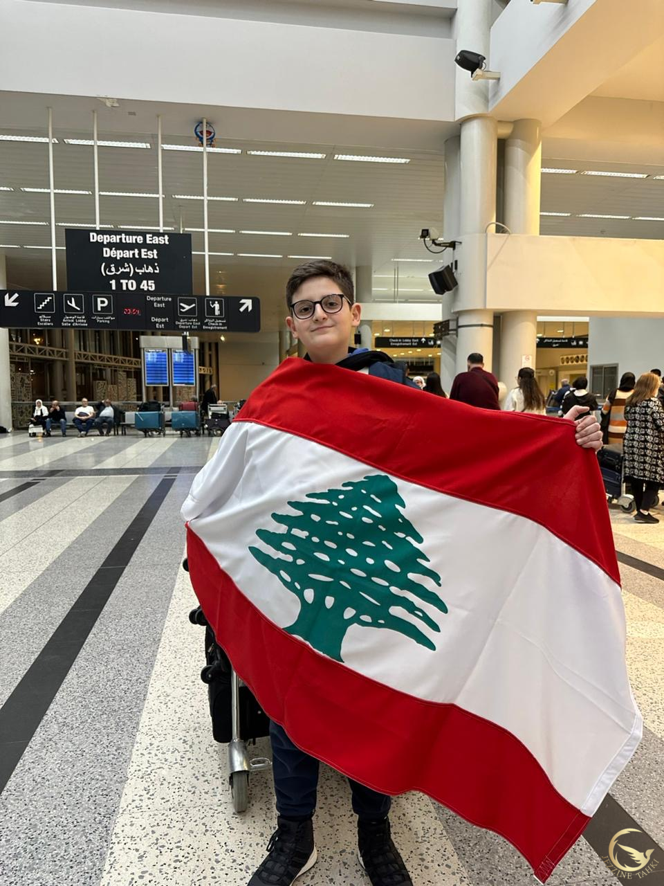 أنطوني جايمس ابو عزيز بالعلم اللبناني في مطار بيروت للانطلاق إلى جورجيا